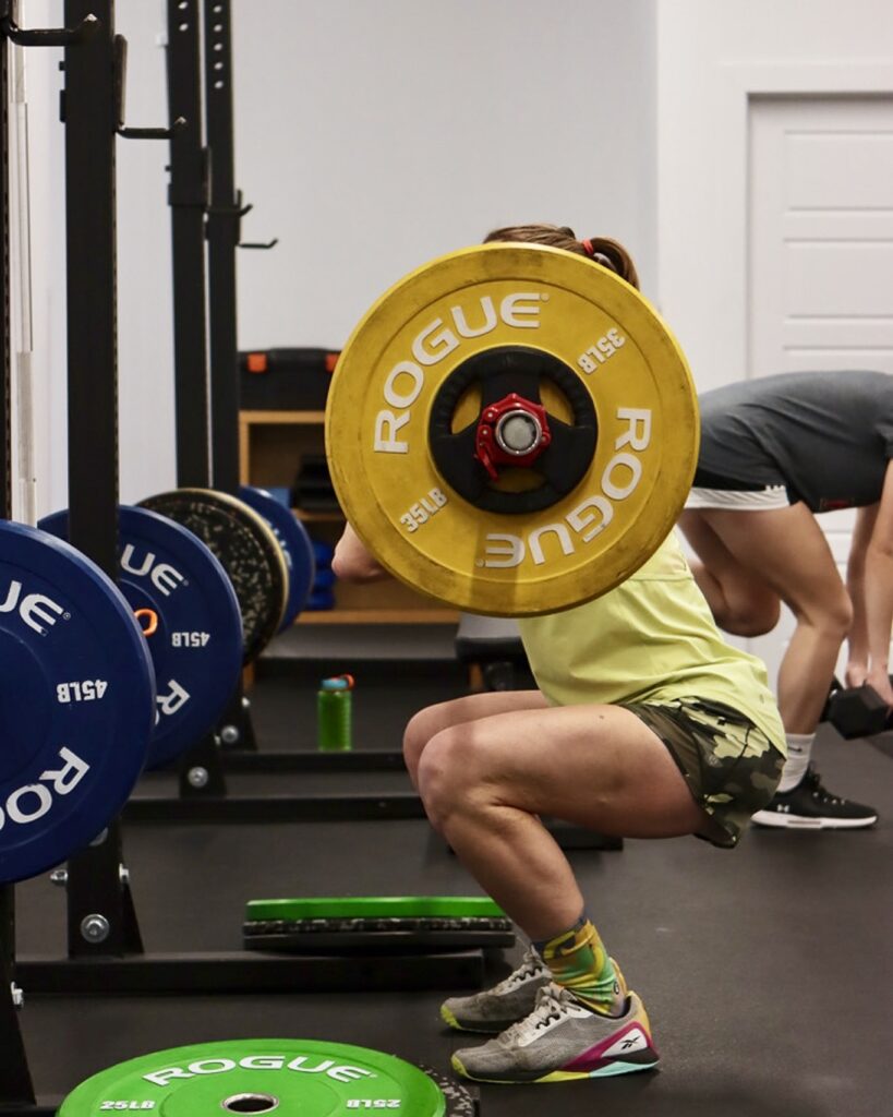 Exercice de squat avec barre pour renforcer les jambes dans le cadre d'un programme de préparation avant une chirurgie du genou.